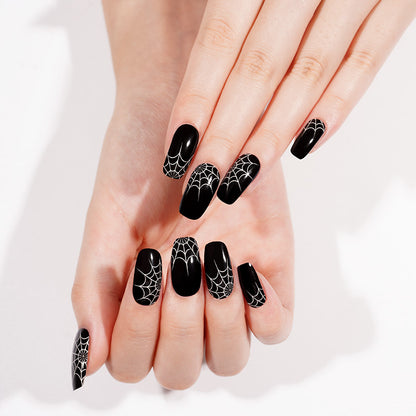Glossy black semi-cured gel wraps with white spiderweb design on coffin-shaped nails
