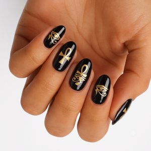 Glossy black nail wraps with gold Egyptian Eye of Horus and ankh symbols.