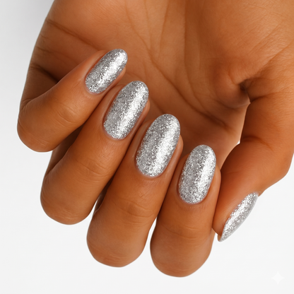Sparkly silver glitter gel nail wraps on hand showing glamorous metallic shine