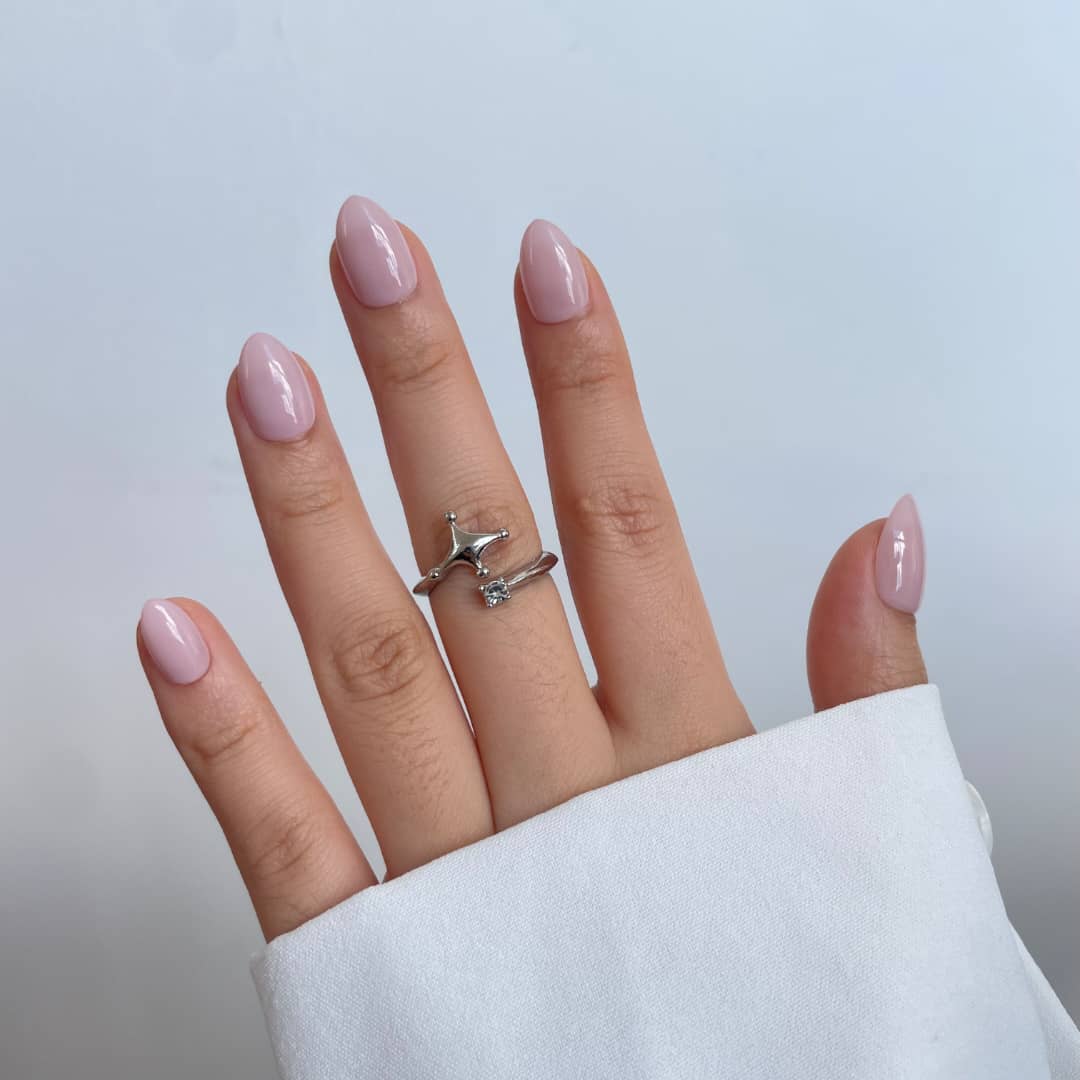 Sheer pink glossy semi-cured gel nail wraps on almond-shaped nails