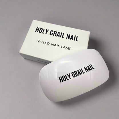 White nail curing lamp next to product box for at-home gel manicures