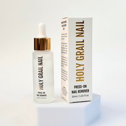 White press-on nail remover bottle with gold dropper and packaging for gentle nail removal