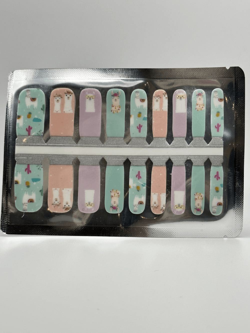 Sheet of kids nail wraps with adorable llama patterns in mint and pink