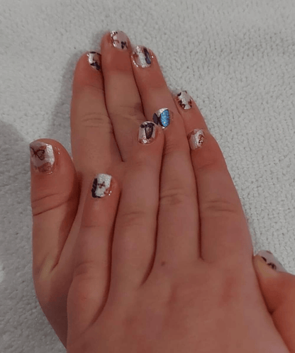 Two hands showing butterfly nail wraps with blue orange pink butterfly nail art