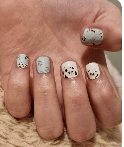 Cute panda kids nail wraps on small hand featuring mint green and white kawaii animal design