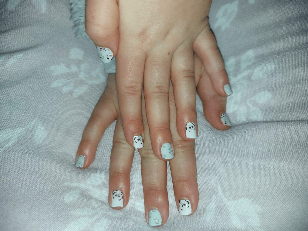 Both hands showing kawaii panda kids nail art wraps in mint green and white colours