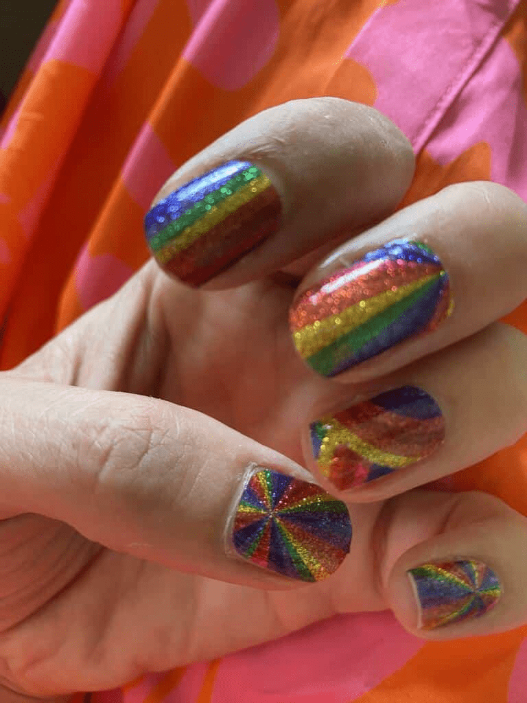 Rainbow striped gel nail wraps on child's hand showing colourful pride nail art