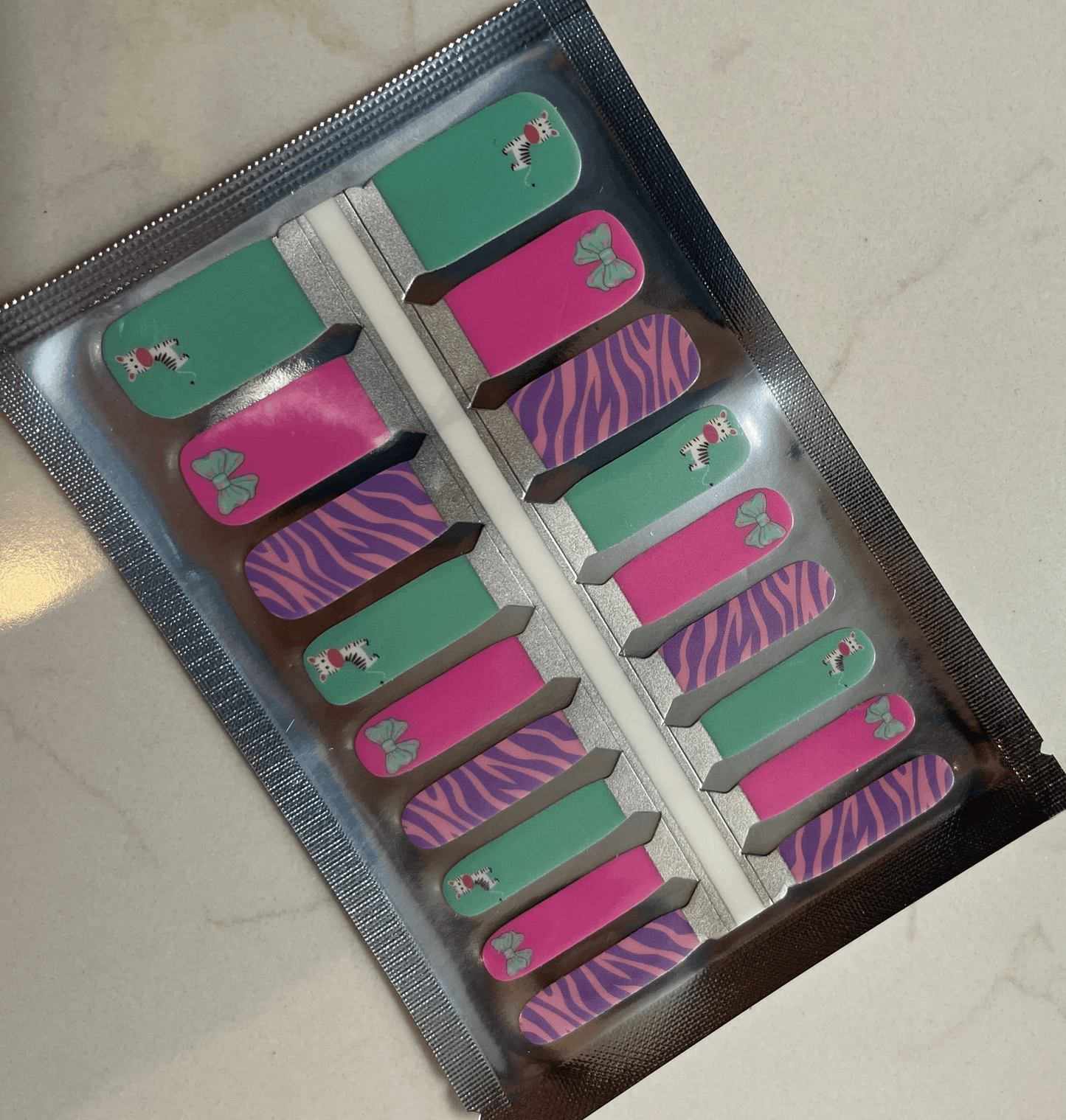 Children's nail wraps set featuring mint zebra and purple stripe patterns in packaging