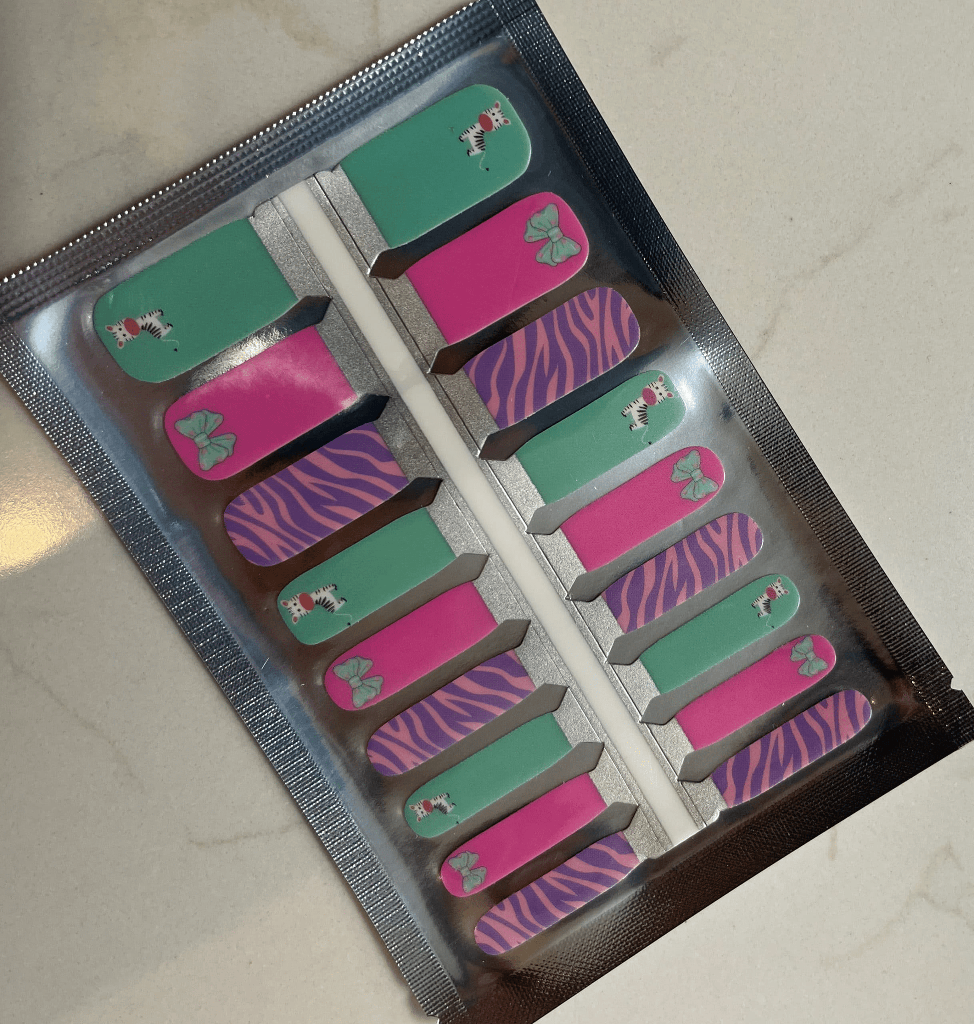 Children's nail wraps set featuring mint zebra and purple stripe patterns in packaging