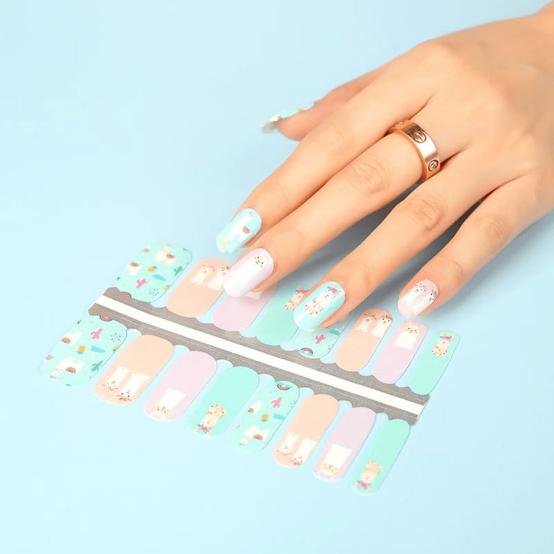 Pastel nail wraps with cute llama designs in pink mint green on hand