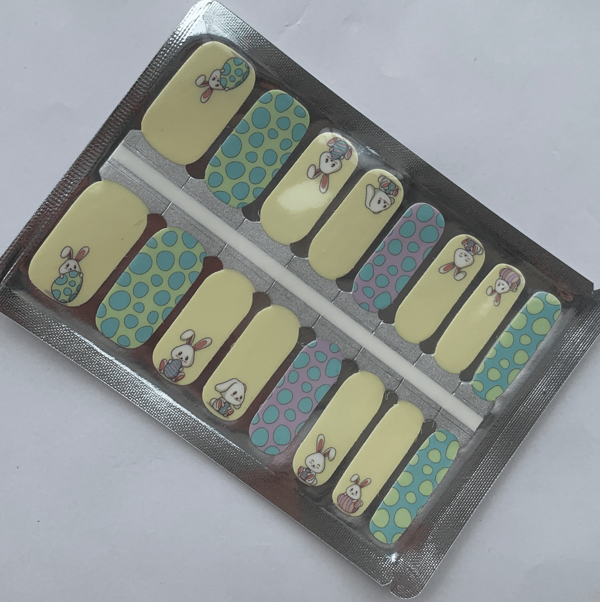 Non-UV nail wraps packaging showing blue and yellow bunny design manicure wraps in foil packet