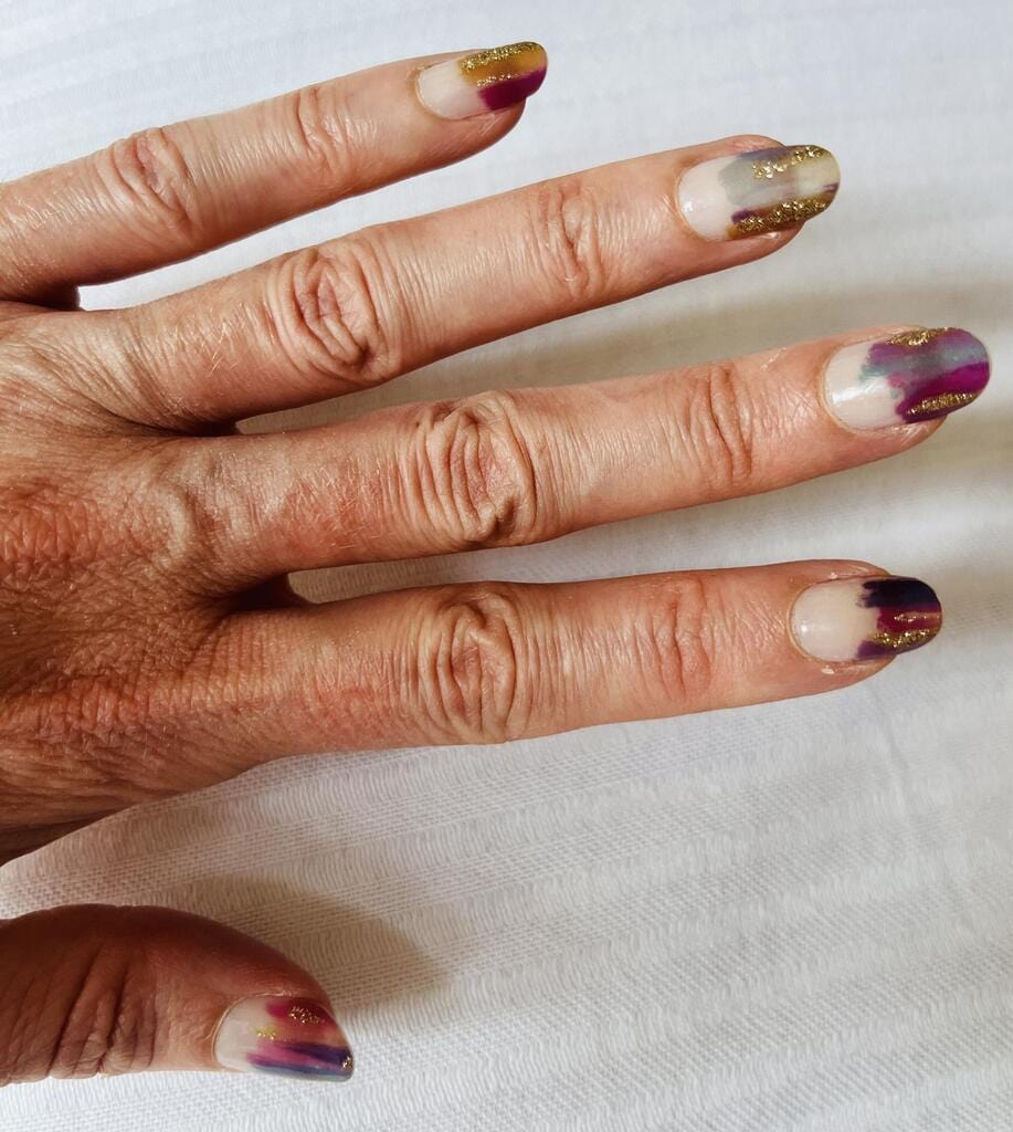 Chrome purple nail wraps on hand showing holographic metallic finish for at-home manicure
