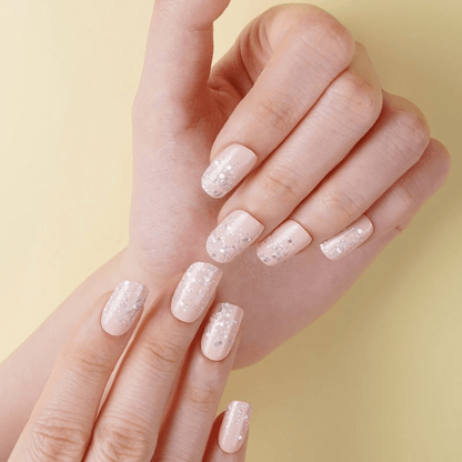 Pink nude glitter nail wraps on hands showing sparkly at-home manicure finish