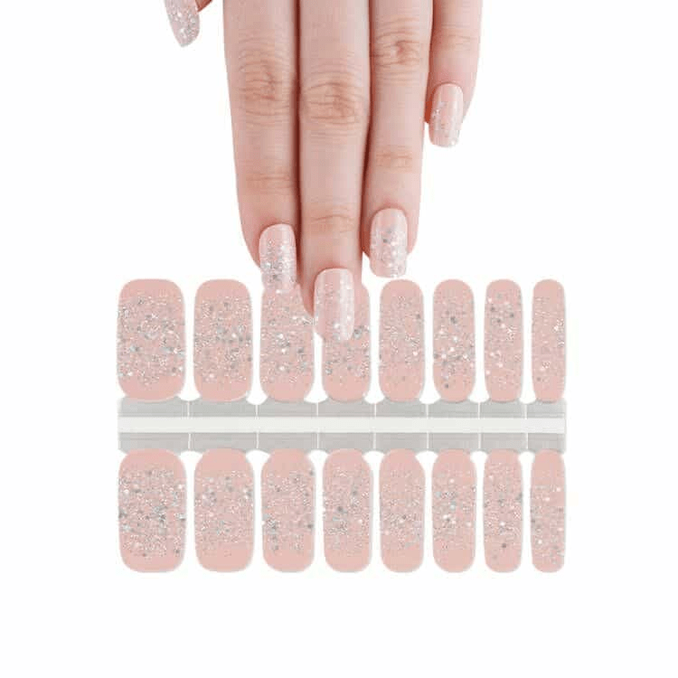 Pink nude glitter nail wraps sheet with hand showing applied manicure