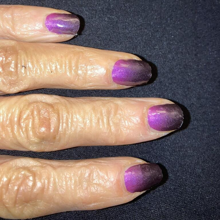 Purple ombré nail wraps on hand showing glossy gradient finish from dark to light purple