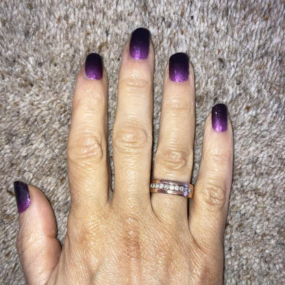 Purple black ombré gradient nail wraps on hand against grey textured background