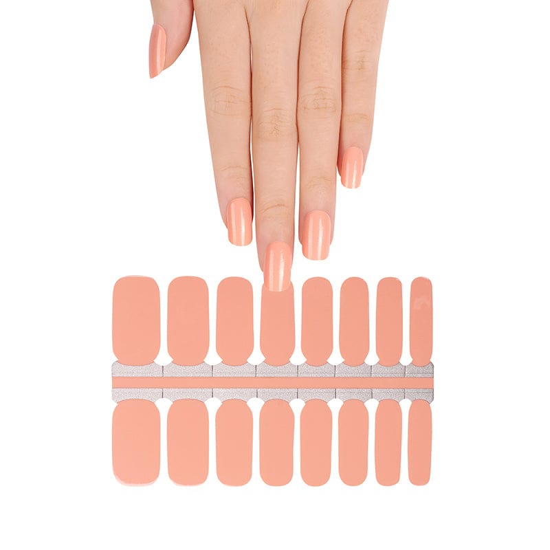 Hand reaching for apricot orange nail wrap strips showing DIY application process