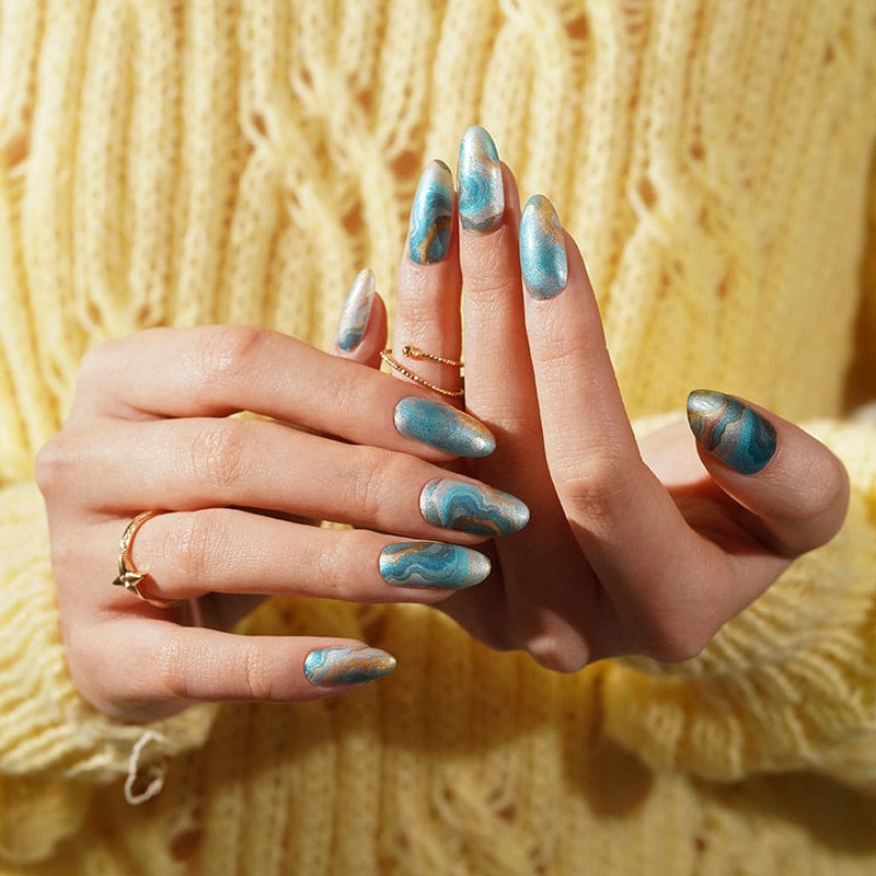 Blue and gold swirl nail wraps showing complete at-home manicure on both hands