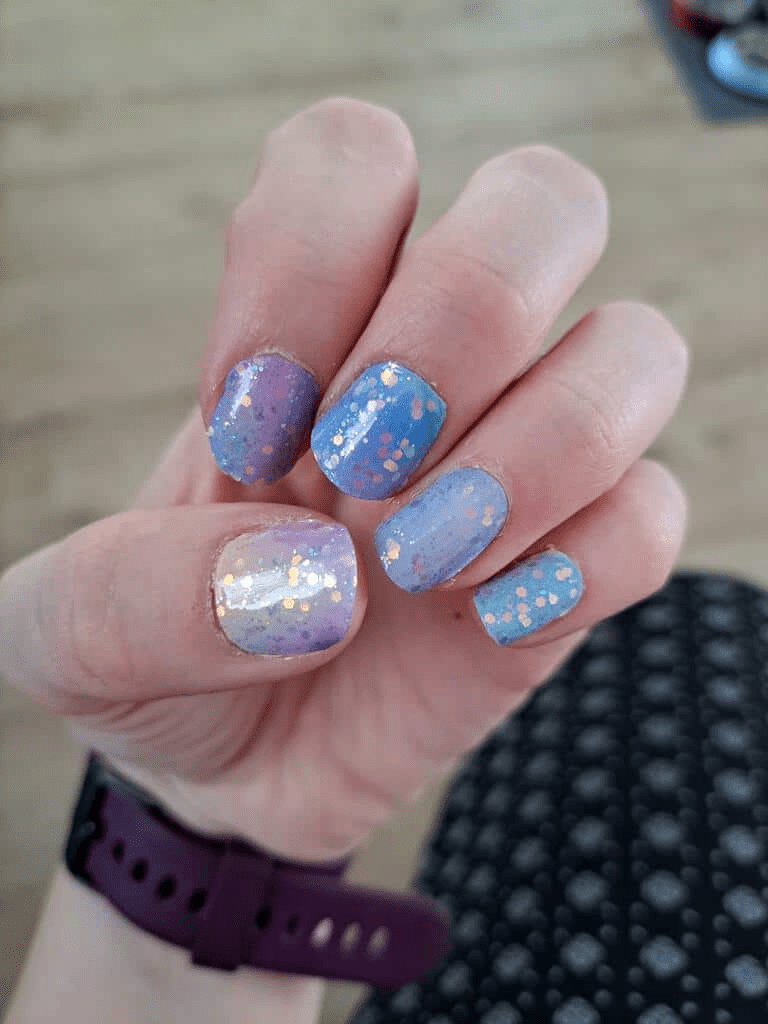 Blue purple ombre nail wraps with holographic glitter sparkles on hand manicure
