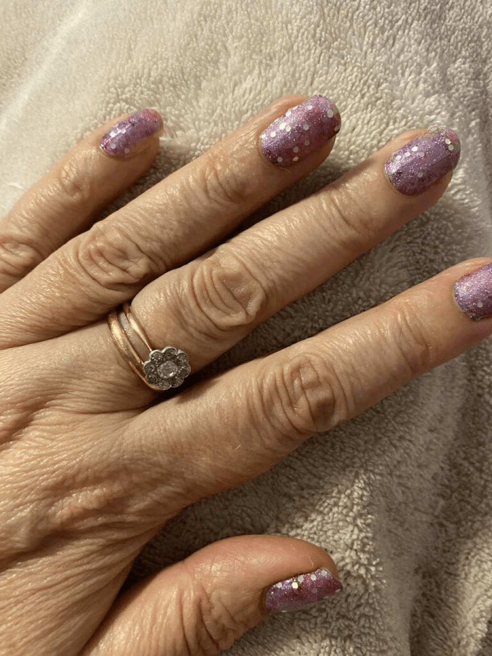 Purple pink glitter gel nail wraps on hand showing sparkly at-home manicure
