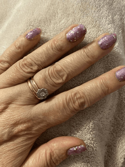 Purple pink glitter gel nail wraps on hand showing sparkly at-home manicure