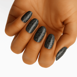 Black marble pattern gel nail wraps applied on hand showing gothic nail art design