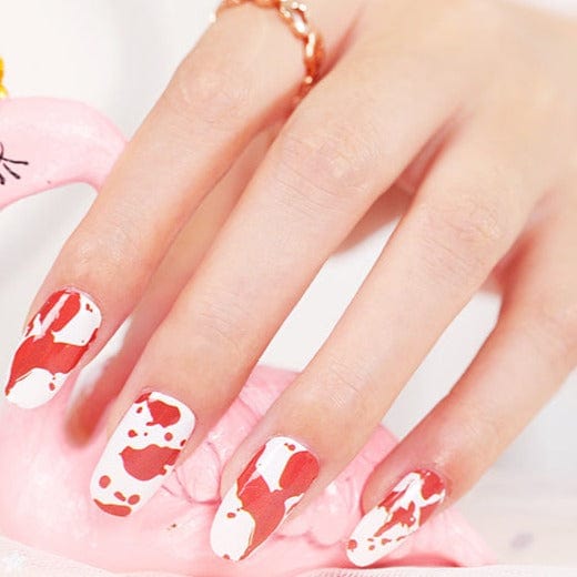 Close-up of red and white blood splatter nail wraps on fingernails