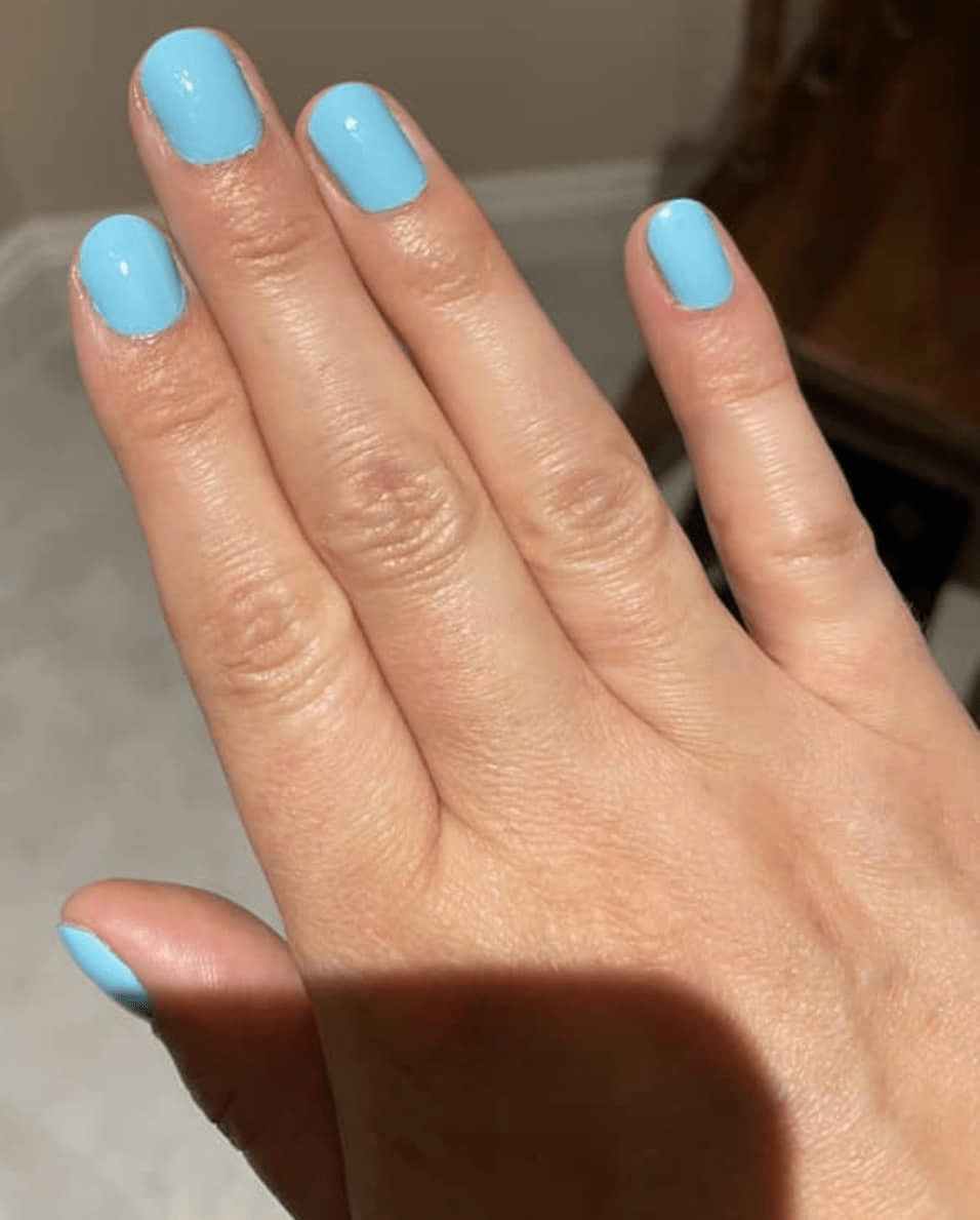 Light blue pastel nail wraps on hand showing smooth glossy finish classic manicure