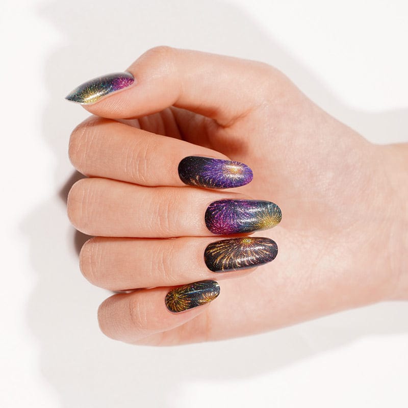 Purple gold firework pattern gel nail wraps on hand for bonfire night manicure
