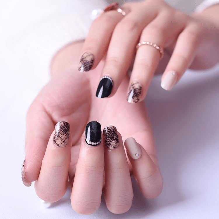 Black and nude boucle textured gel nail wraps on hands showing glitter pattern nail art
