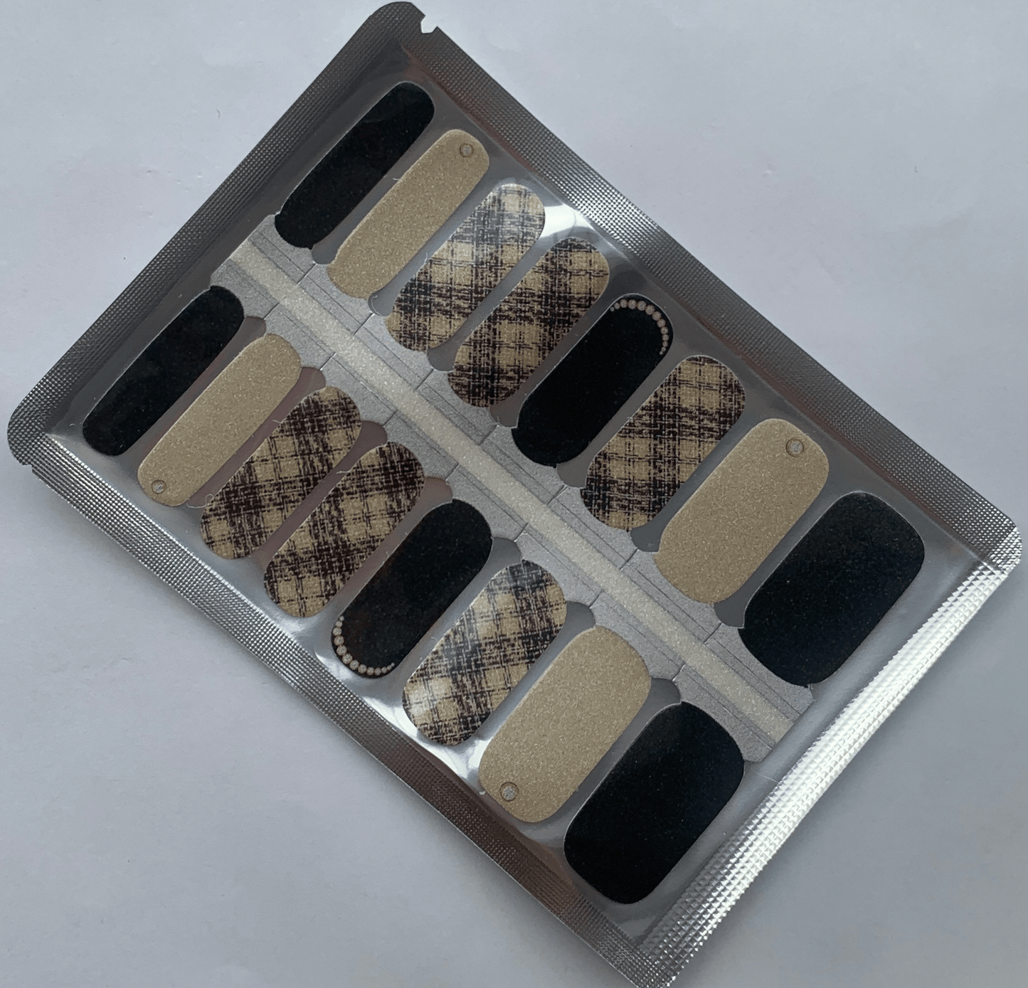 Beige tweed pattern nail wraps with black accents and glitter finish for classic manicure