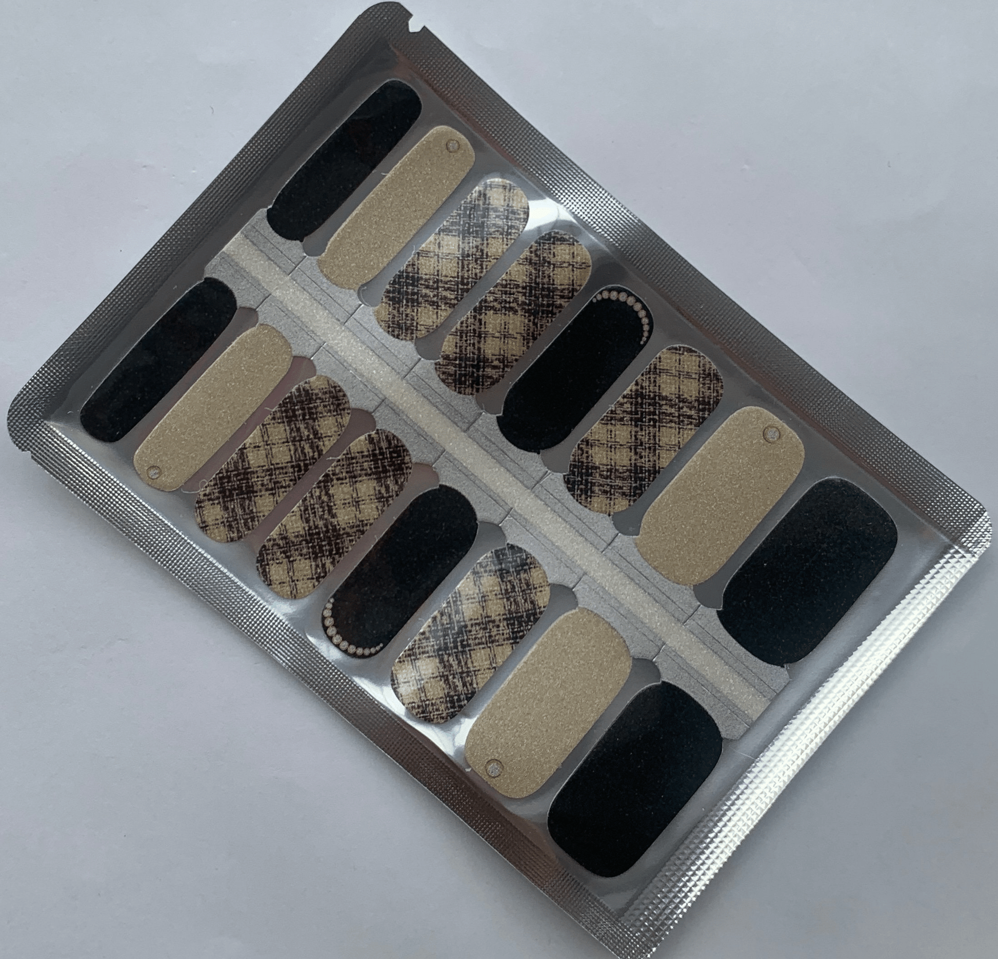 Beige tweed pattern nail wraps with black accents and glitter finish for classic manicure