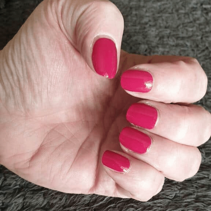 Hot pink gel nail wraps on hand displaying smooth glossy manicure