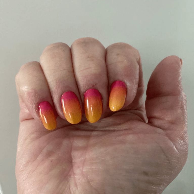 Red to yellow ombre gradient nail wraps on hand showing sunset manicure design