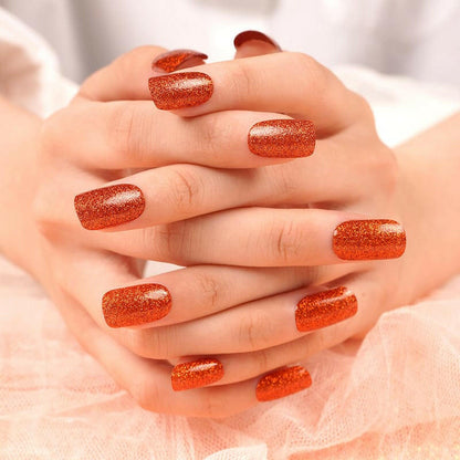 Burnt sienna glitter nail wraps on hands showing sparkly orange-brown manicure finish