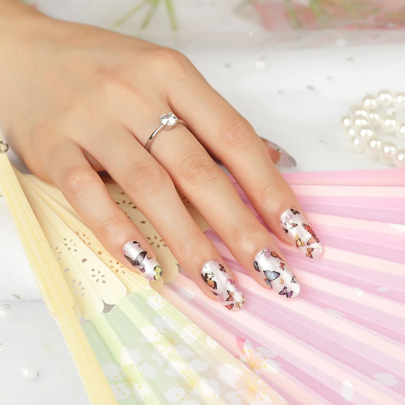 White nail wraps with colourful butterfly pattern on hand showing manicure
