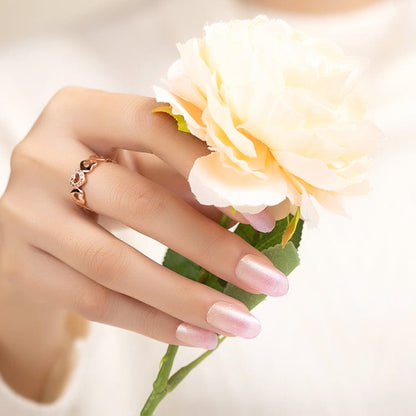 Pink ombre nail wraps on hand holding white flower, gradient manicure design