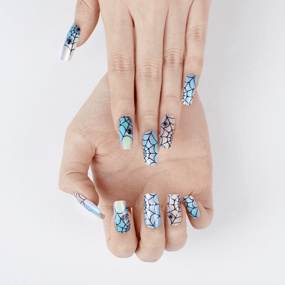 Both hands displaying holographic spider web nail wraps for Halloween gothic manicure