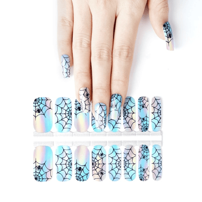 Holographic spider web nail wraps on hand with blue and silver Halloween gothic design