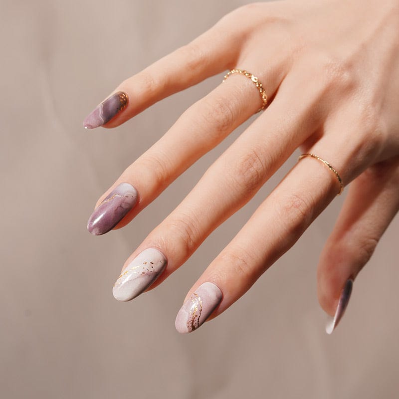 Purple marble nail wraps with gold foil finish on hand showing at-home manicure results
