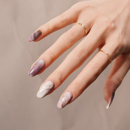 Purple marble nail wraps with gold foil finish on hand showing at-home manicure results