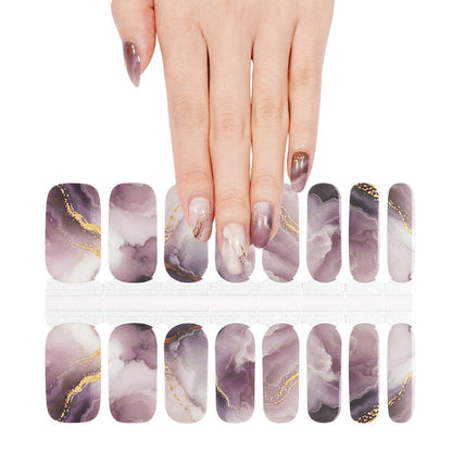 Purple marble gel nail wraps with gold foil accents displayed with matching manicured hand
