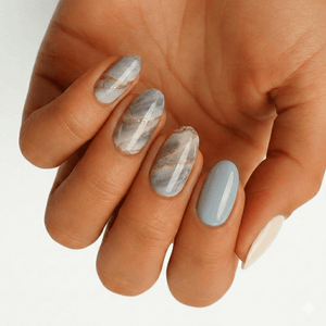 Grey marble nail wraps on hand showing elegant stone pattern manicure design