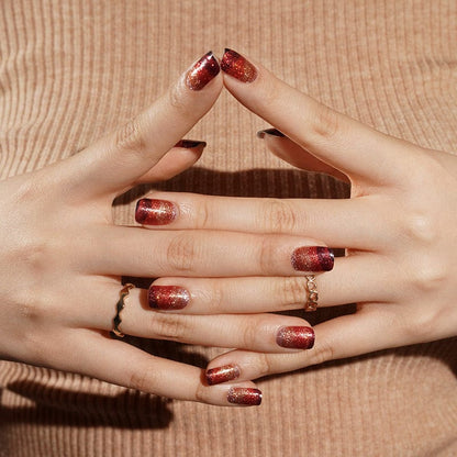 Hands with red to black gradient glitter nail wraps in interlocked finger pose