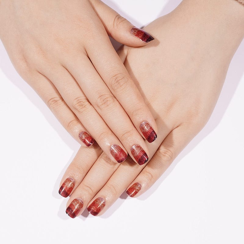 Overlapping hands showcasing red and black ombre glitter nail art wraps manicure