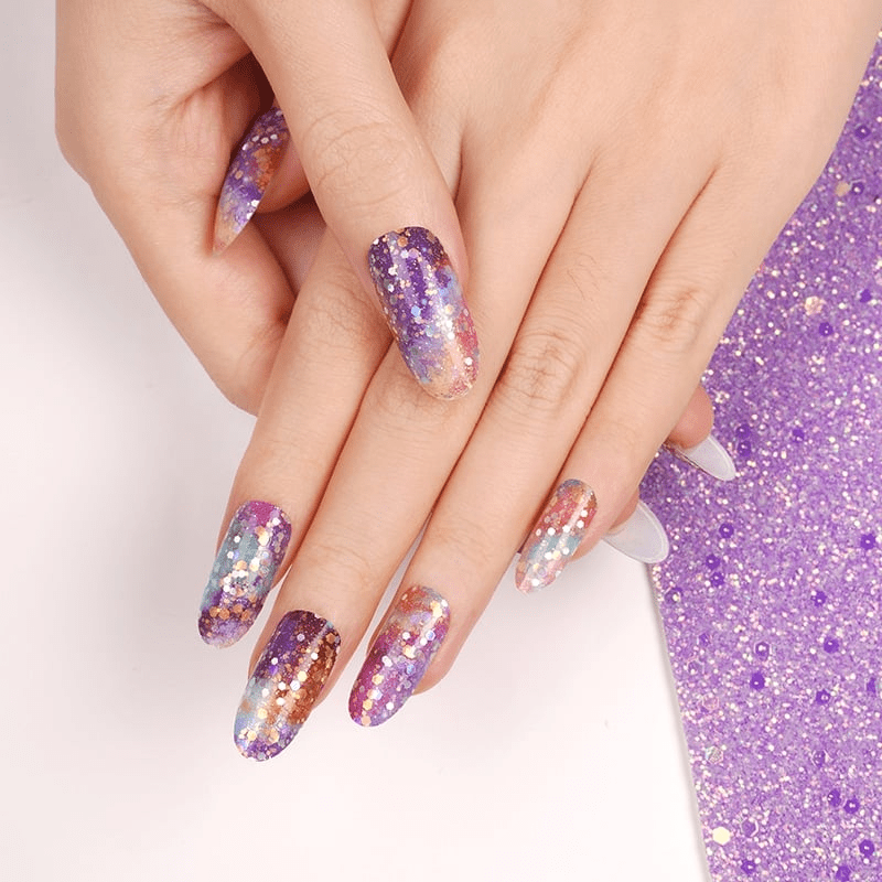 Purple glitter gel nail wraps applied on hand showing sparkly galaxy design