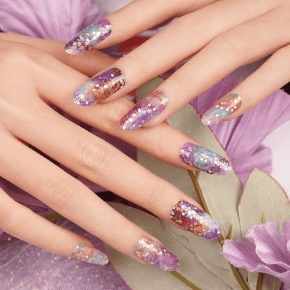 Galaxy sparkle nail wraps on manicured hand with purple flowers nail art design