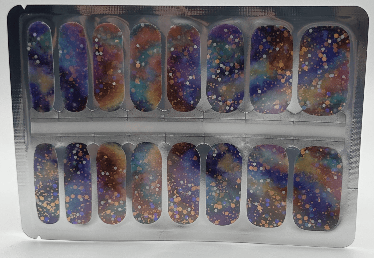 Cosmic glitter nail wraps in packaging featuring purple blue gold sparkle nail art