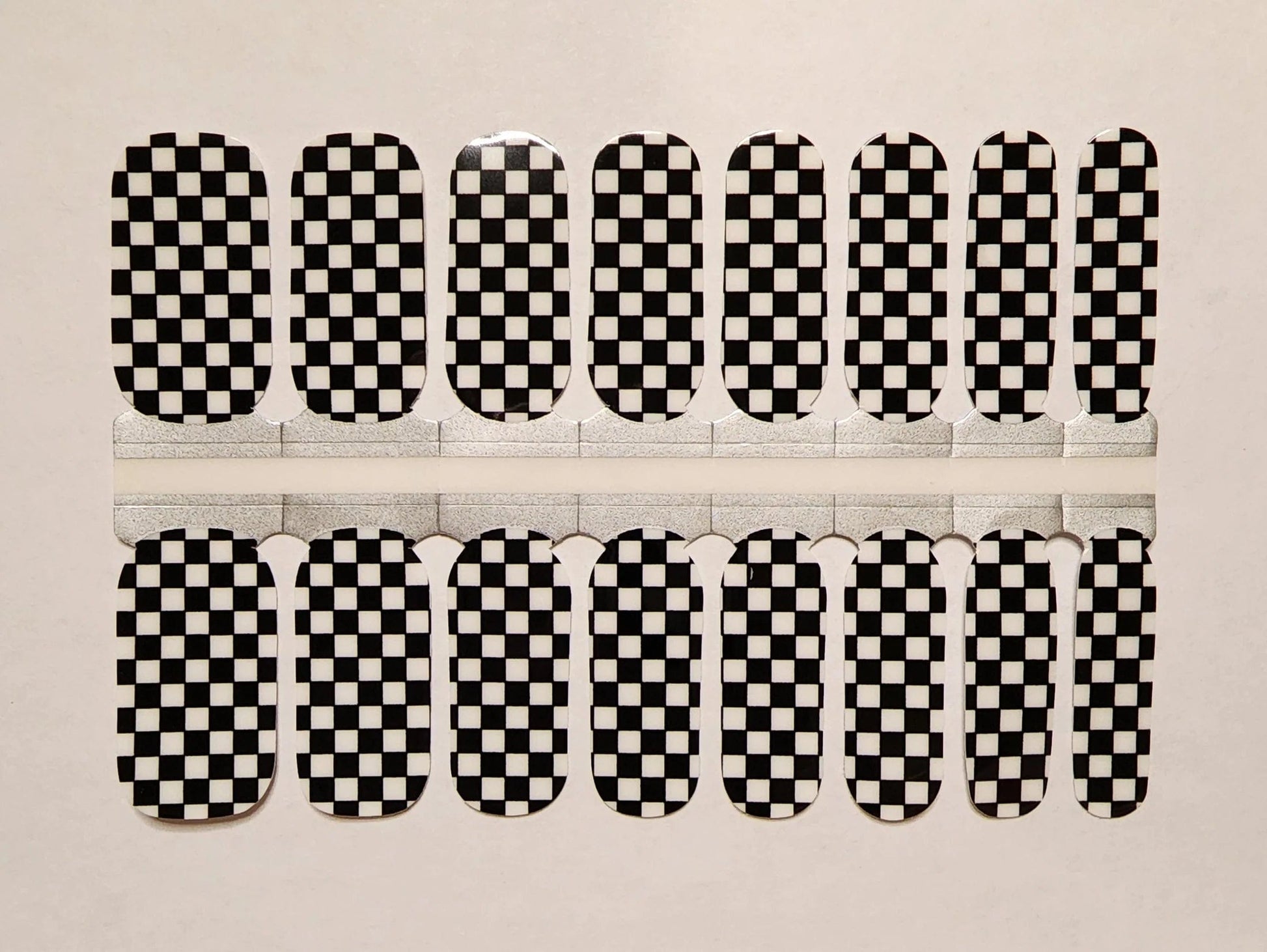 Black and white checkered nail wraps in classic checkerboard pattern for at-home manicure