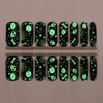 Glow in the dark gothic nail wraps glowing green with skull patterns